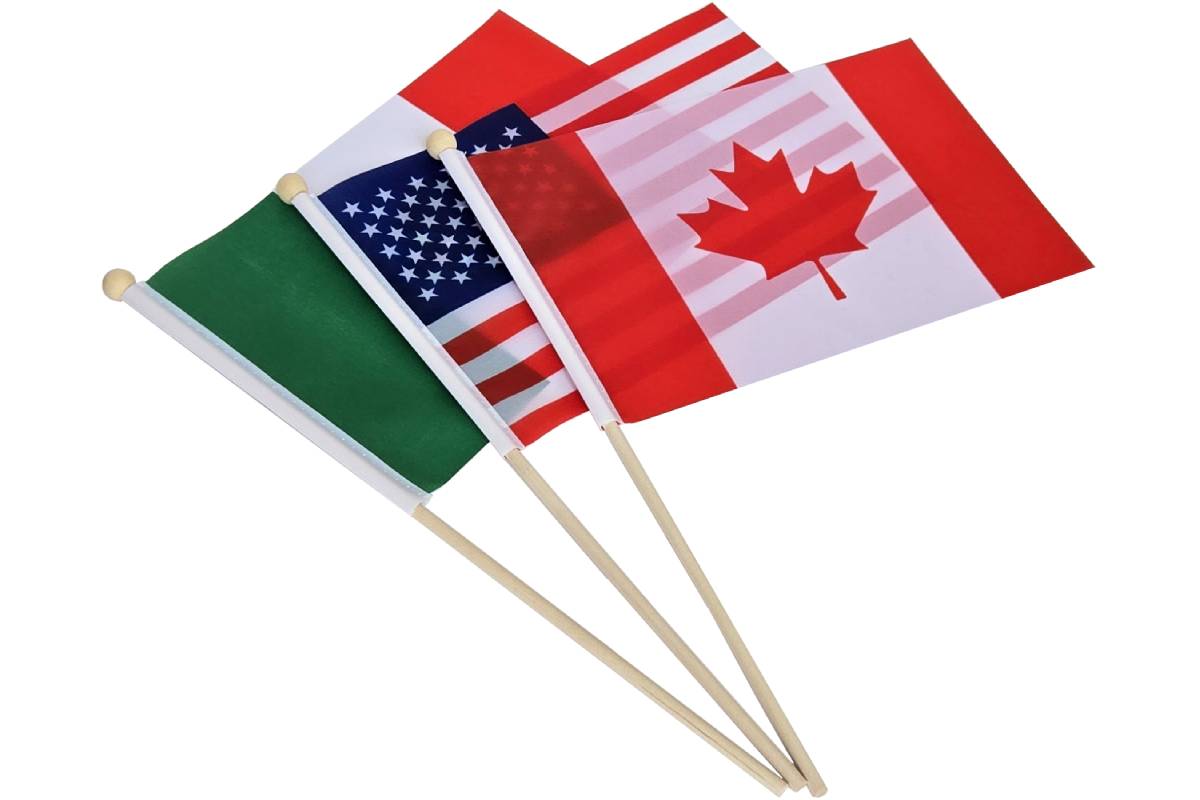 Three flags on wooden flagpoles: Canada, the USA, and Mexico.