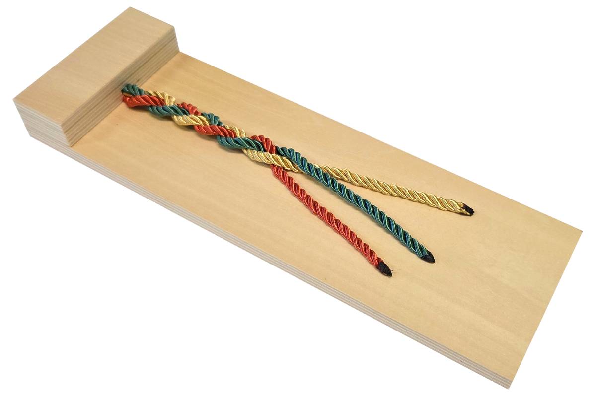 Wooden board with three ropes in different colours. The ropes are braided together.