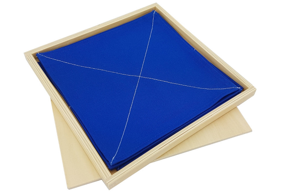Folding clothes activity in a wooden box with lid. Fabric squares are blue with white stitching to fold along.