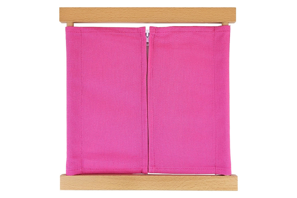 Wooden zipper dressing frame with pink fabric and white zipper.