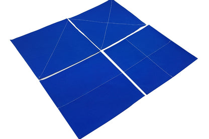 Four blue fabric squares with white stitches to fold along. Squares have a single diagonal, two diagonals, one horizontal, or both a horizontal and vertical fold.