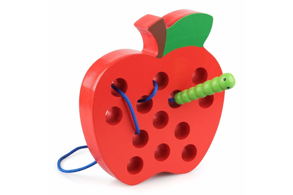 Red wooden apple with holes and a green worm attached to a string. Worm is threaded through the holes.
