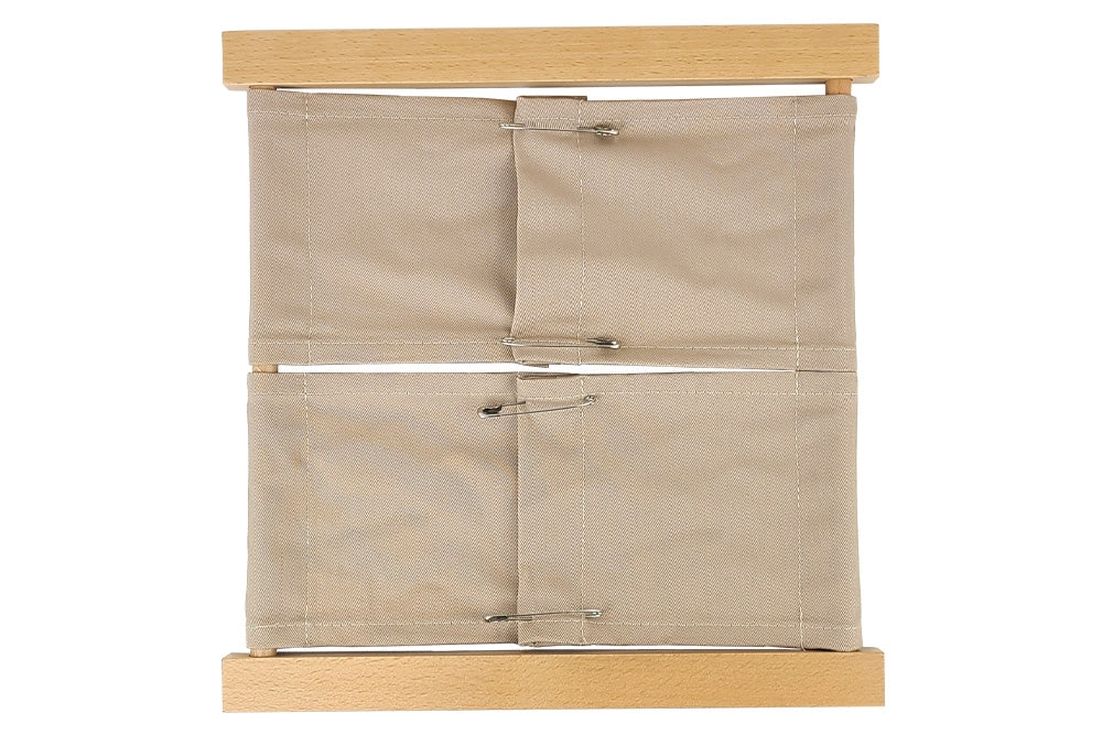 Wooden safety pin dressing frame with beige fabric in two sections.