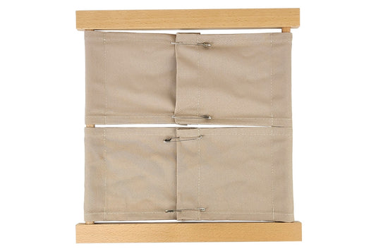 Wooden safety pin dressing frame with beige fabric in two sections.
