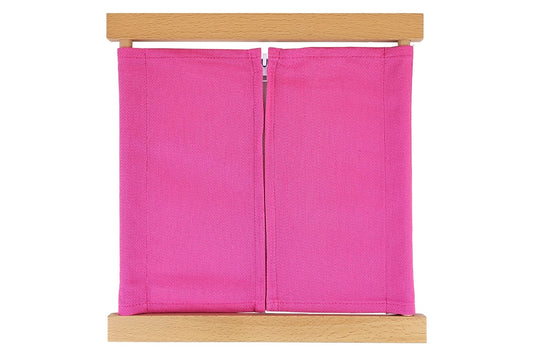 Wooden zipper dressing frame with pink fabric and white zipper.