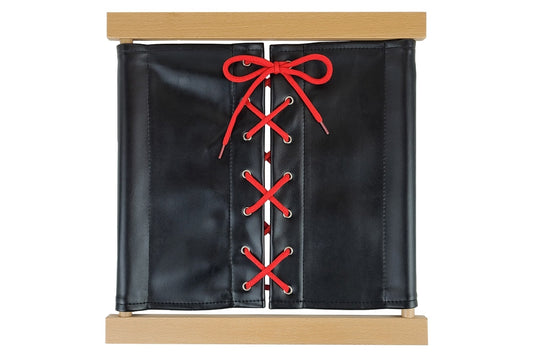Wooden shoe-lacing dressing frame with black fabric and red laces.
