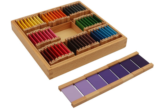 Third colour tablet box with nine compartments. Each compartment contains seven tablets of different shades of a colour: yellow, orange, grey, pink, purple, green, red, brown, and blue. The purple tablets are laid out in front of the box in a gradient from lightest to darkest.